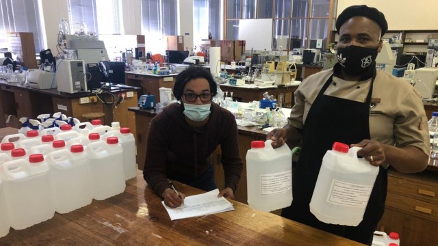 Ronn Mager and Siyasanga Nkuna from Residential Operations at Rhodes bckapp_bck-άƽ̨ collect hand sanitiser from the Pharmacy Faculty to start preparations for the next group of returning students